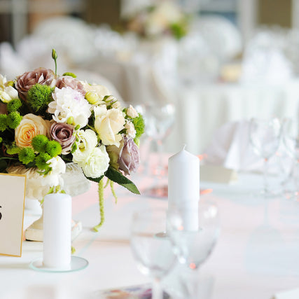 Wedding RentalsA close-up of set wedding tables with flower bouquets centered on them.